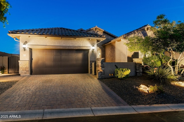 8633 E Kael Cir, Mesa, AZ 85207 - view of front of house with stucco siding, stone siding, a gate, an attached garage, and decorative driveway