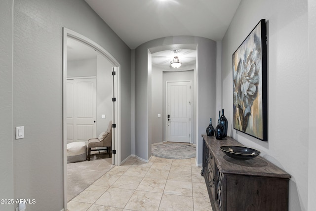 8633 E Kael Cir, Mesa, AZ 85207 - hall with arched walkways, light marble finish flooring, and baseboards