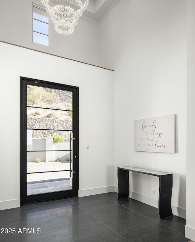 foyer entrance featuring an inviting chandelier and a towering ceiling