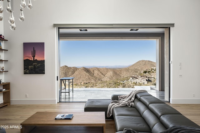 living room with a chandelier, a mountain view, and hardwood / wood-style floors