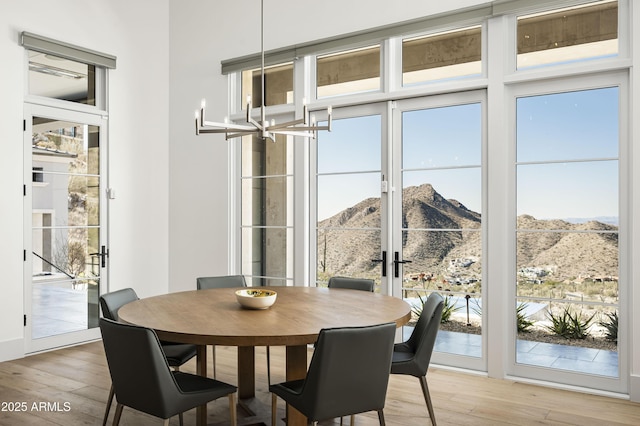 dining room with floor to ceiling windows, a mountain view, and hardwood / wood-style floors