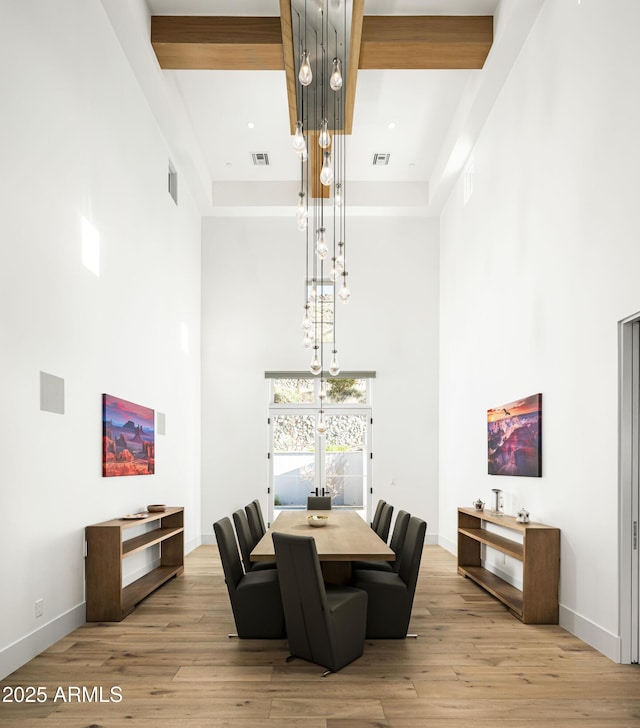 dining room featuring a high ceiling and light wood-type flooring