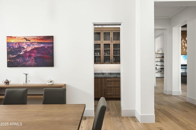 dining space with bar and light hardwood / wood-style flooring