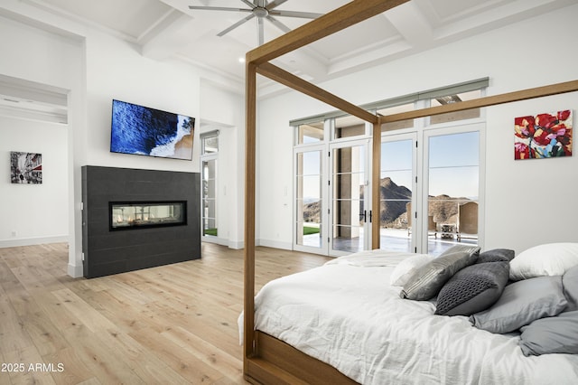 bedroom with multiple windows, access to exterior, coffered ceiling, and light wood-type flooring