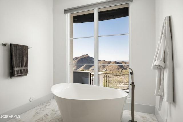 bathroom with a mountain view and a tub