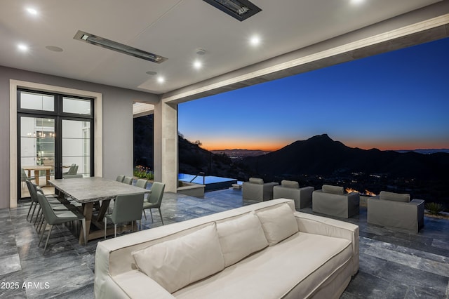 patio terrace at dusk featuring an outdoor living space and a mountain view