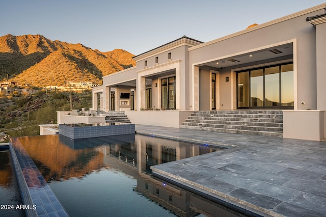 rear view of property with a mountain view and a patio area