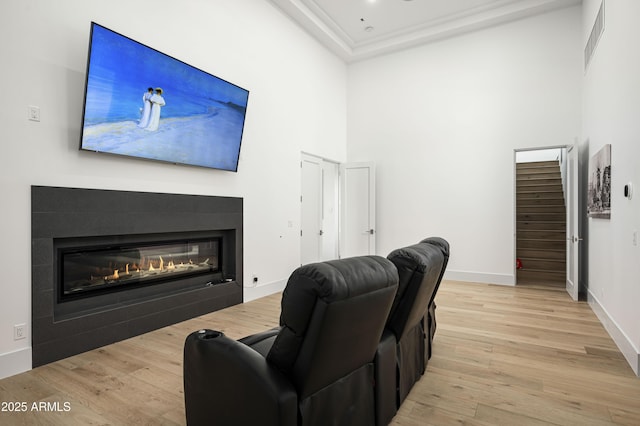 living room featuring a towering ceiling and light hardwood / wood-style floors