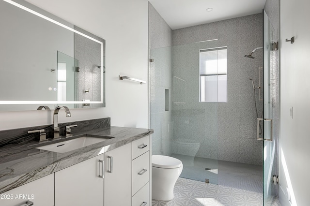 bathroom featuring vanity, an enclosed shower, and toilet