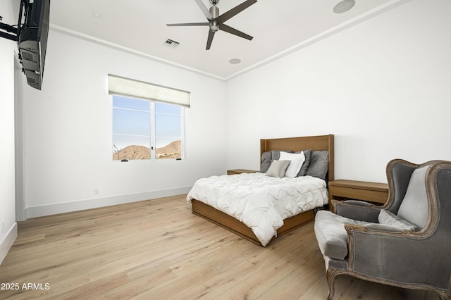 bedroom featuring light hardwood / wood-style flooring, ornamental molding, and ceiling fan