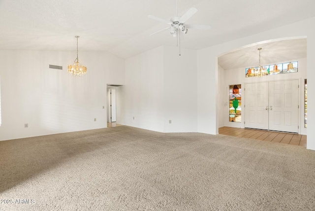 interior space with ceiling fan with notable chandelier and lofted ceiling