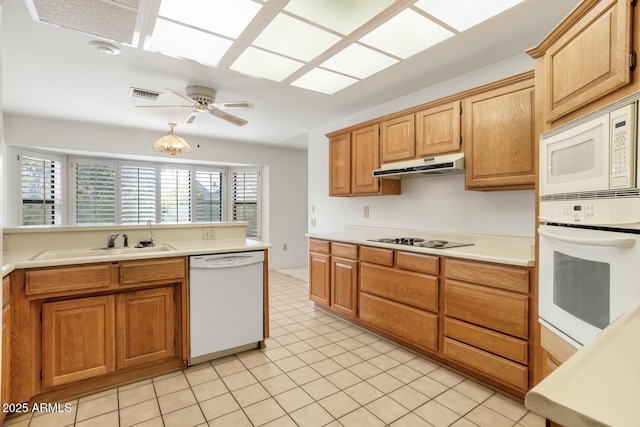 kitchen featuring ceiling fan, sink, light tile patterned floors, white appliances, and a skylight