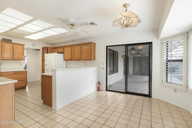 kitchen with white fridge with ice dispenser, ceiling fan with notable chandelier, pendant lighting, and light tile patterned flooring