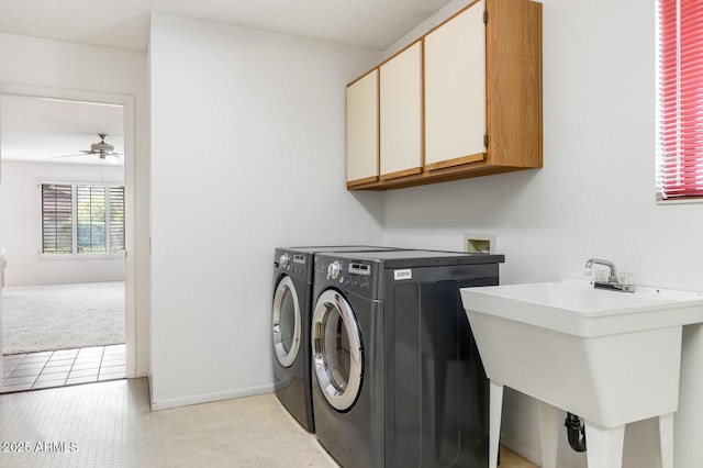 laundry room featuring cabinets, washing machine and clothes dryer, sink, ceiling fan, and light tile patterned floors