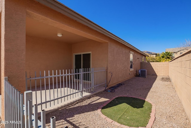 view of side of property with a patio and central air condition unit