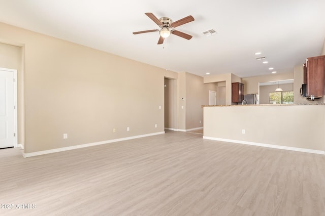 unfurnished living room with light hardwood / wood-style flooring and ceiling fan