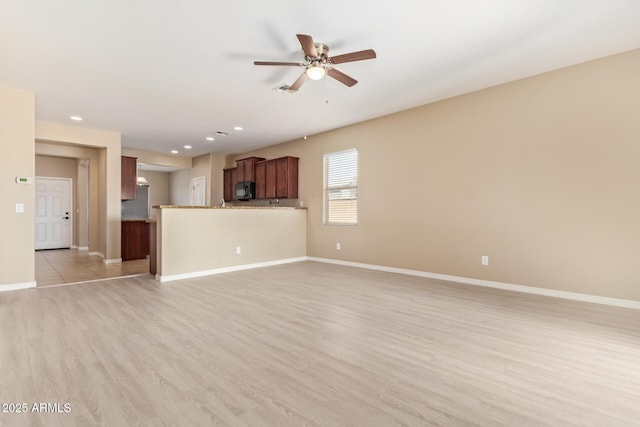 unfurnished living room featuring light hardwood / wood-style flooring and ceiling fan