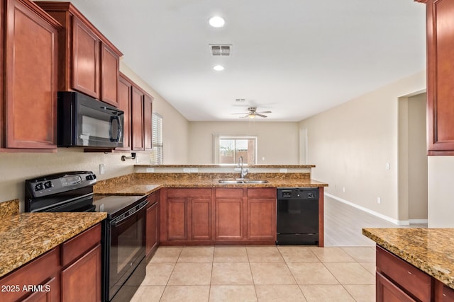 kitchen featuring light stone countertops, sink, and black appliances