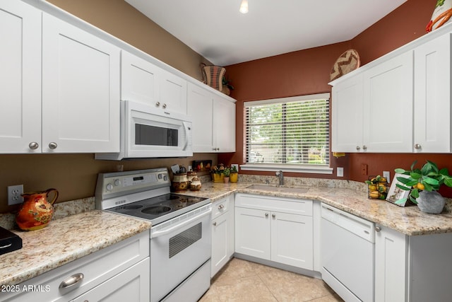 kitchen featuring a sink, white appliances, light tile patterned flooring, white cabinets, and light stone countertops