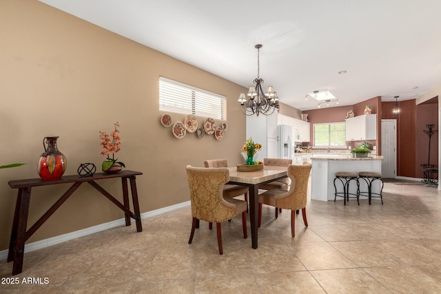 dining room featuring baseboards and a notable chandelier