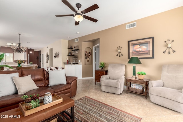 living area featuring ceiling fan with notable chandelier, light tile patterned floors, and visible vents