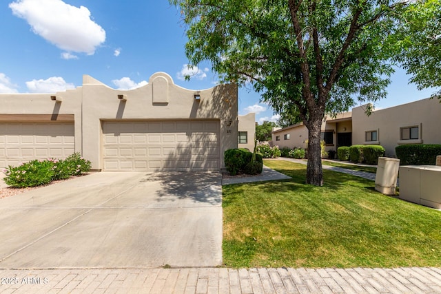 pueblo revival-style home with an attached garage, a front yard, stucco siding, and driveway