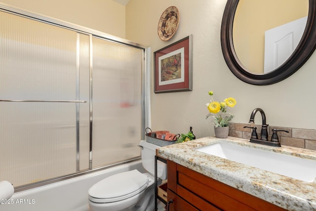 full bathroom with toilet, vanity, and enclosed tub / shower combo