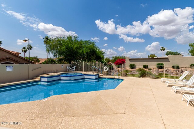 pool featuring a patio area, a community hot tub, and fence