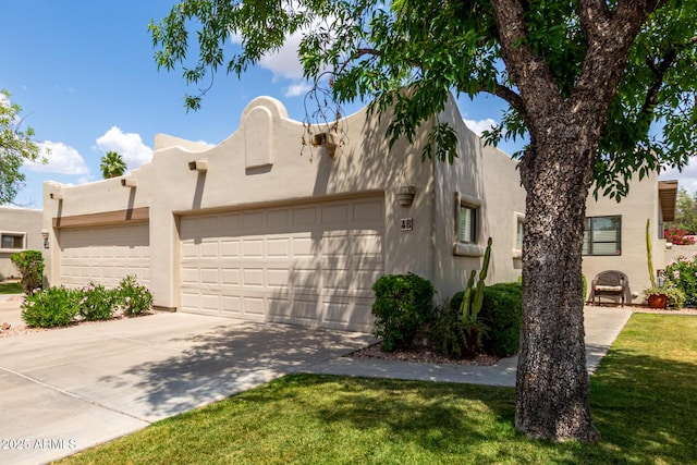 view of front of house featuring a front yard, an attached garage, stucco siding, and driveway