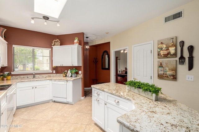 kitchen featuring a sink, a skylight, white cabinetry, visible vents, and white appliances