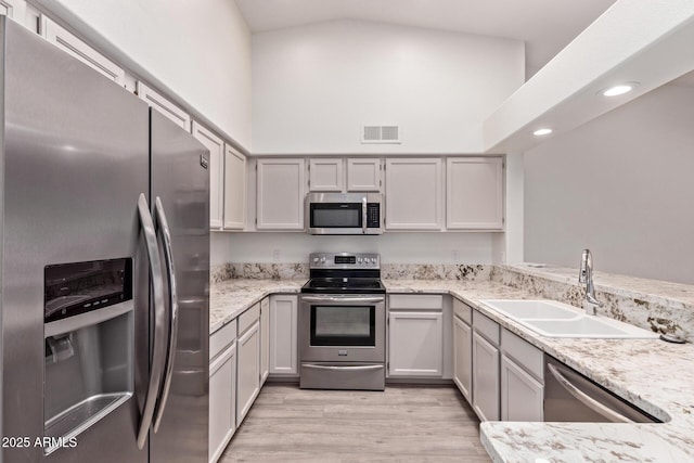 1021 S Greenfield Rd Unit 1211, Mesa, AZ 85206 - kitchen featuring stainless steel appliances, light wood-type flooring, light stone counters, high vaulted ceiling, and recessed lighting