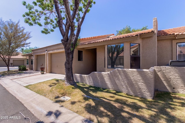 1021 S Greenfield Rd Unit 1211, Mesa, AZ 85206 - view of front facade featuring stucco siding, driveway, a garage, and a tiled roof