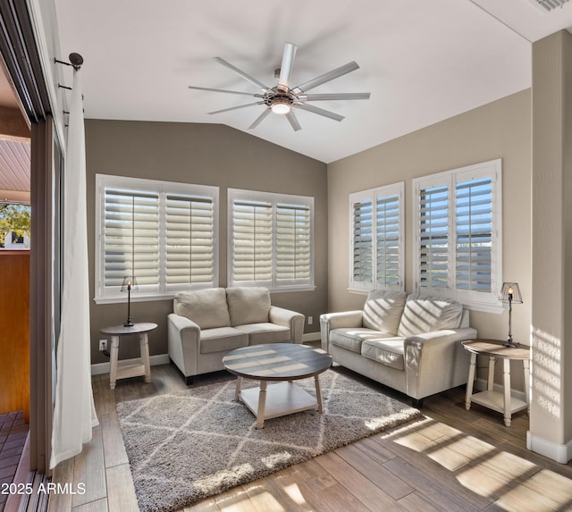 living area with a ceiling fan, vaulted ceiling, baseboards, and wood finished floors