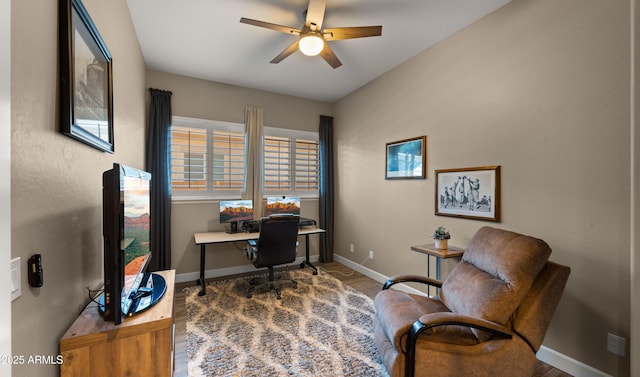 office space featuring a ceiling fan, baseboards, and wood finished floors