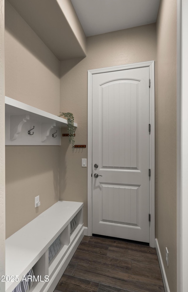 mudroom with dark wood-style flooring and baseboards