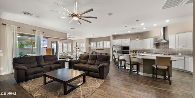 living area featuring dark wood-style floors, visible vents, and ceiling fan