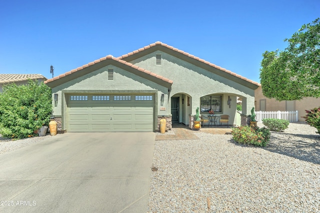2101 S Meridian Rd Unit 250, Apache Junction, AZ 85120 - mediterranean / spanish-style house with an attached garage, fence, driveway, stucco siding, and a tile roof