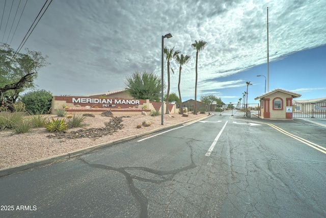 2101 S Meridian Rd Unit 250, Apache Junction, AZ 85120 - view of asphalt road with street lights, a gate, curbs, and a gated entry