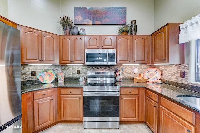 2101 S Meridian Rd Unit 250, Apache Junction, AZ 85120 - kitchen featuring appliances with stainless steel finishes, dark stone counters, decorative backsplash, and brown cabinets