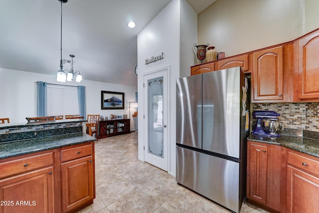 2101 S Meridian Rd Unit 250, Apache Junction, AZ 85120 - kitchen with freestanding refrigerator, backsplash, brown cabinetry, pendant lighting, and light tile patterned floors