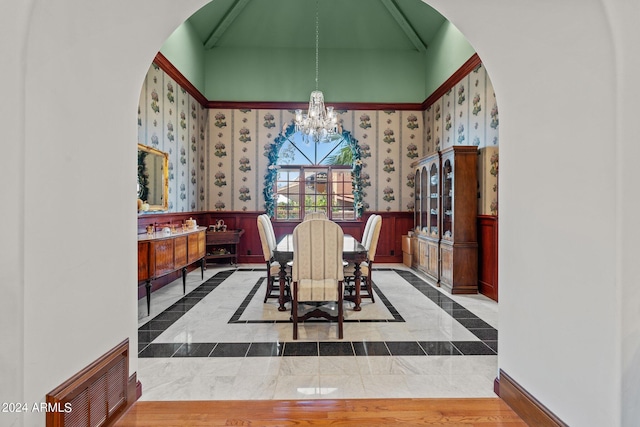 dining room featuring a notable chandelier, light tile floors, and a towering ceiling