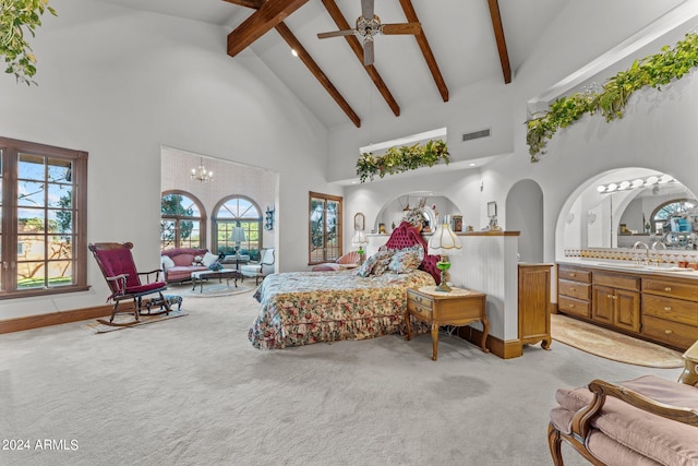 carpeted bedroom with high vaulted ceiling, sink, and ceiling fan with notable chandelier