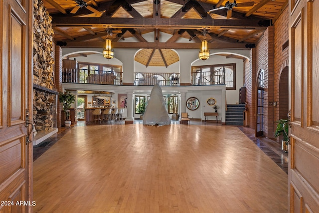 foyer featuring dark hardwood / wood-style flooring, high vaulted ceiling, beamed ceiling, and ceiling fan