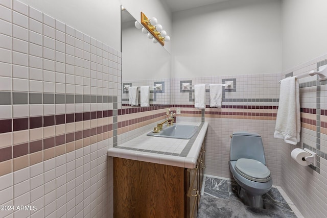 bathroom with tile walls, toilet, and vanity