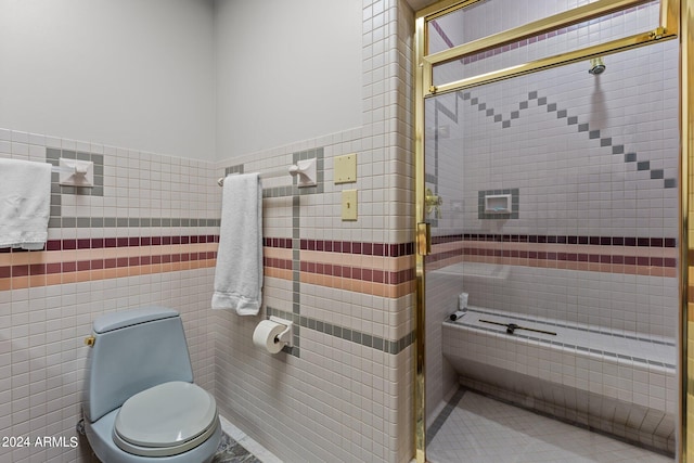 bathroom with tile walls, toilet, and a tile shower