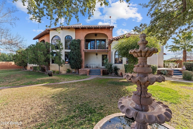 mediterranean / spanish-style house with a balcony and a front yard