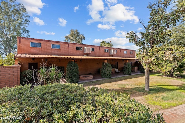 multi unit property featuring a patio area and a front yard