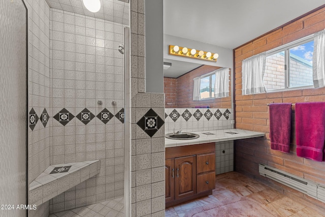 bathroom featuring tile flooring, vanity with extensive cabinet space, a wealth of natural light, and tiled shower