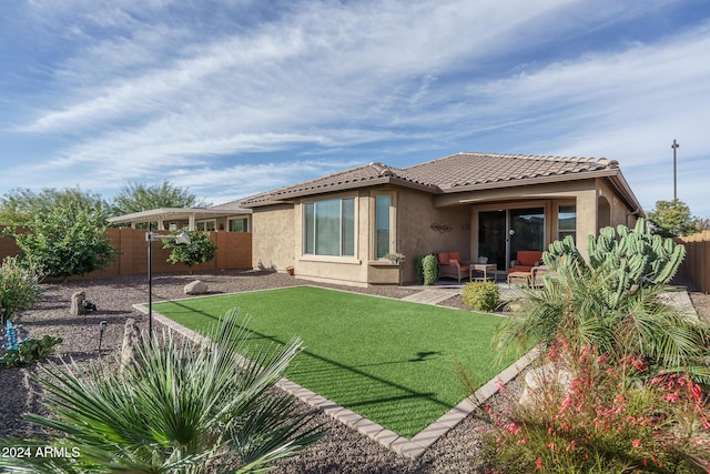 back of property with a lawn and a patio