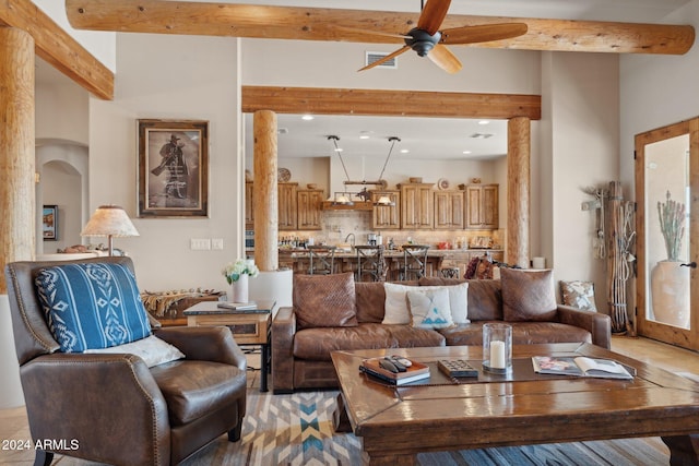 living room featuring beam ceiling, a towering ceiling, and ceiling fan